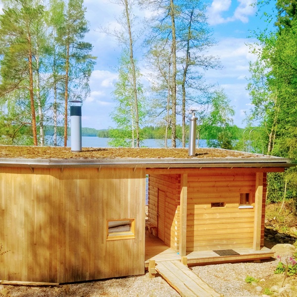 Puinen ulkovuoraus ja sammalkatto saavat tämän saunarakennuksen istumaan luontevasti ympäristöönsä.
